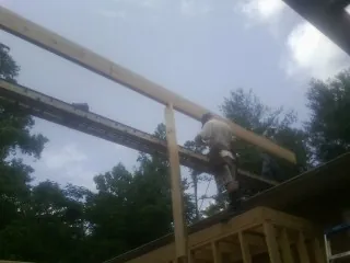 Carpenter setting a ridge beam over a new addition frame — Ice Dam Removal by Roofing Brothers in Richboro