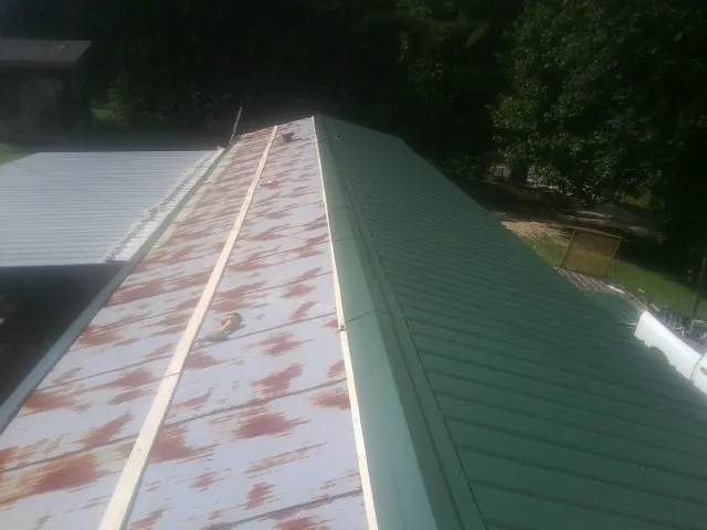 Old rusted panels beside newly installed green metal roofing — Wind Damage Roof Repair by Roofing Brothers in Richboro