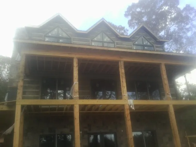 Dormers and porch framing on a large log home under construction — Roof Coating work by our crew in Richboro